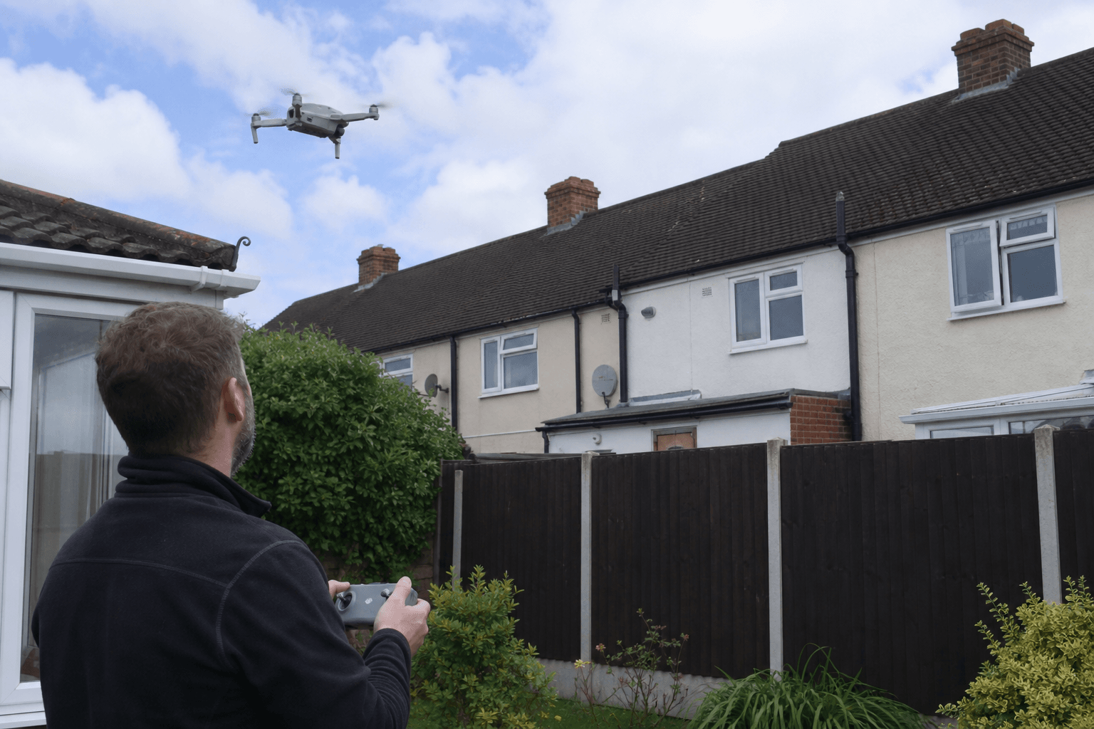 Drone roof inspection over UK suburban rooftops and gutters