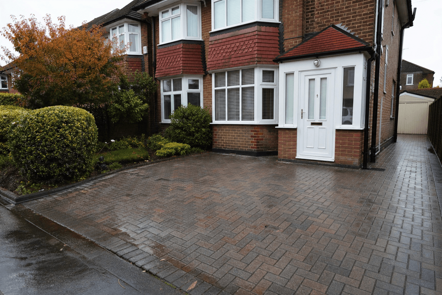 UK suburban driveway with grey block paving showing typical wear