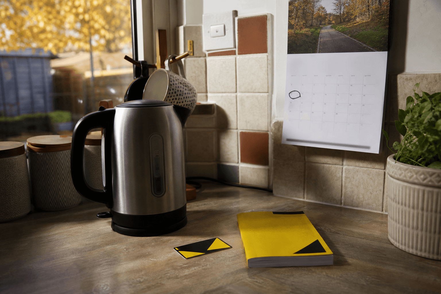 UK kitchen worktop with October circled on wall calendar, Gas Safe card and Benchmark logbook