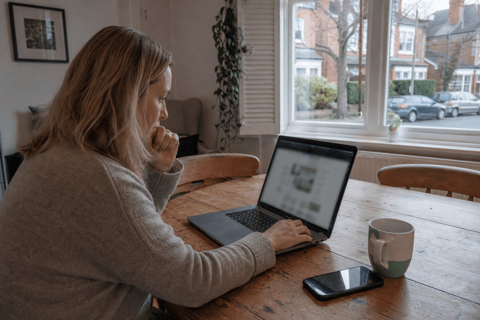 UK homeowner searching for trusted house cleaners on a laptop at home