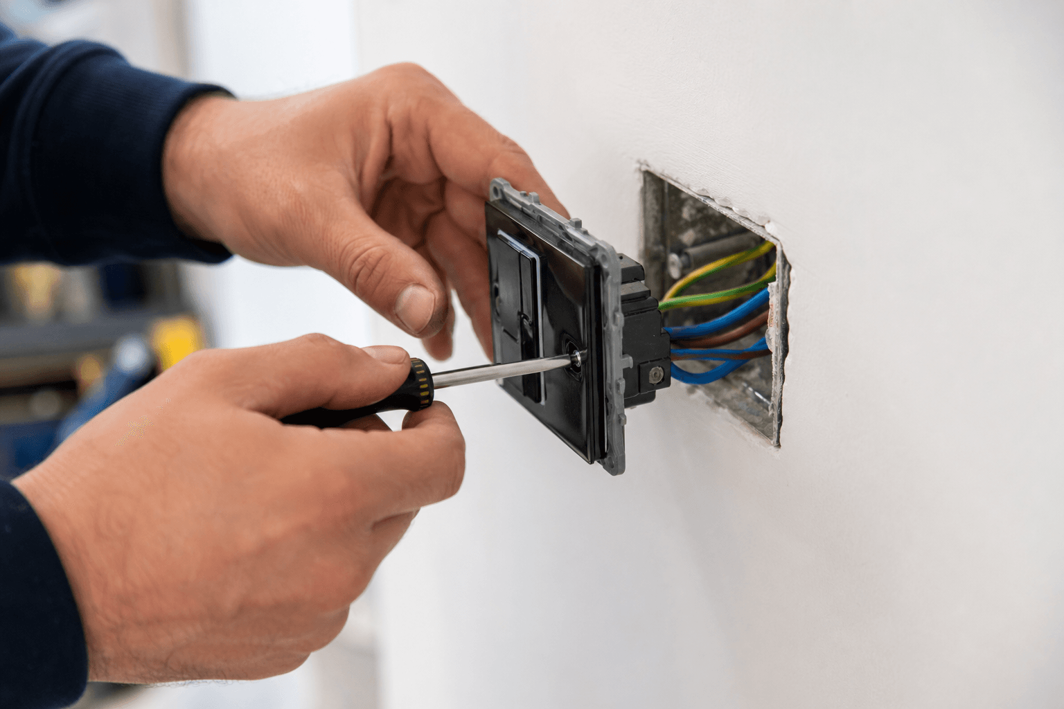Electrician fitting a modern wall light switch in a UK home [dedupe:taskino:blog:smart-home-redo-lessons-uk:inline-1]