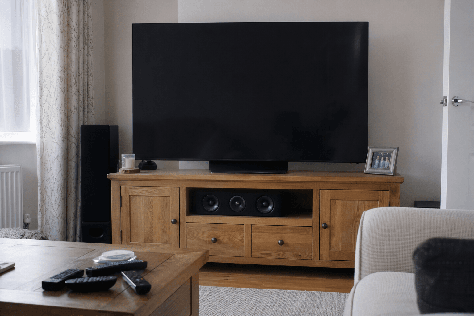 Television on stand with media unit and centre speaker shelf [dedupe:taskino:blog:tv-wall-mount-vs-stand-uk-guide:inline-1]