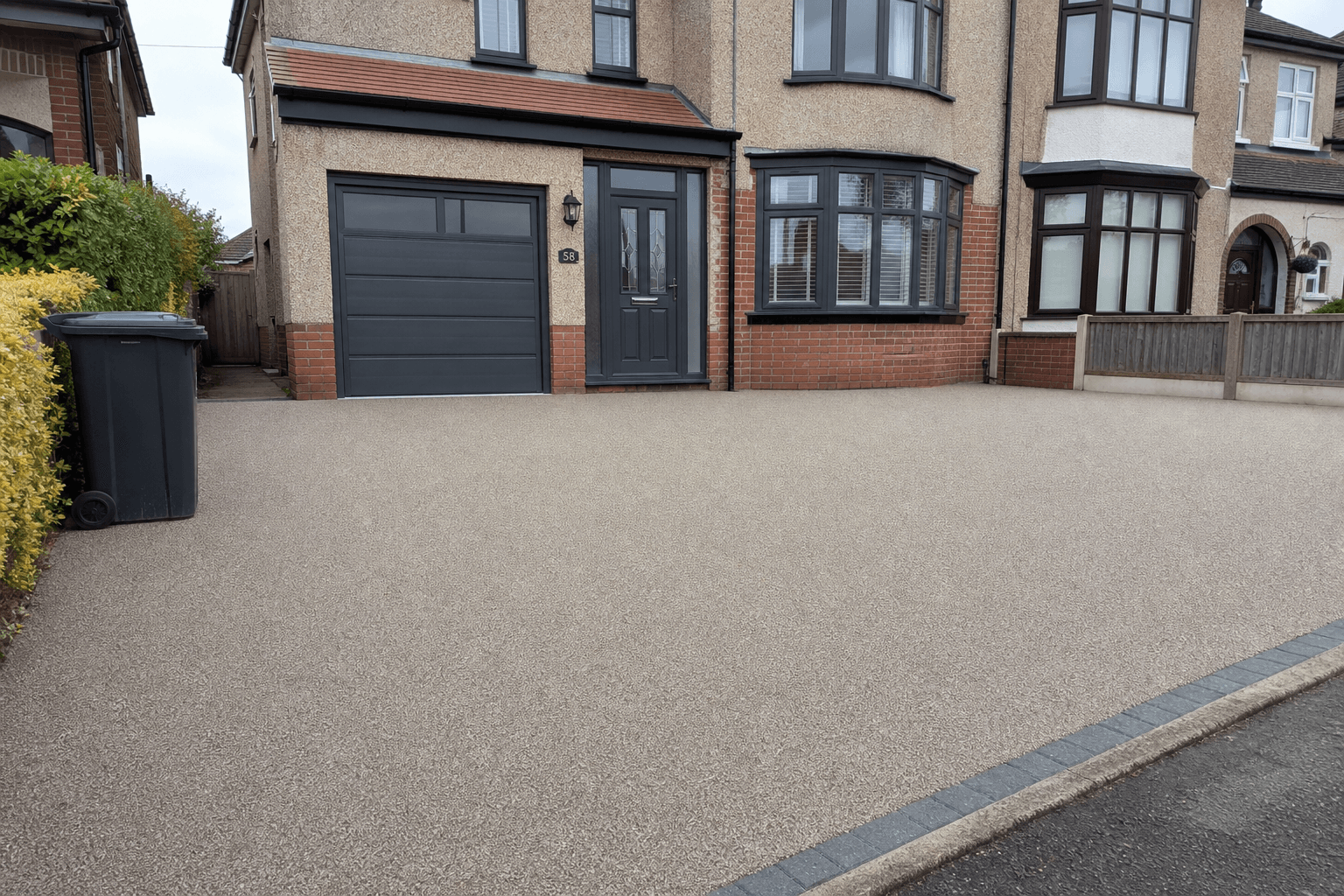 Smooth resin-bound driveway outside a UK semi-detached house
