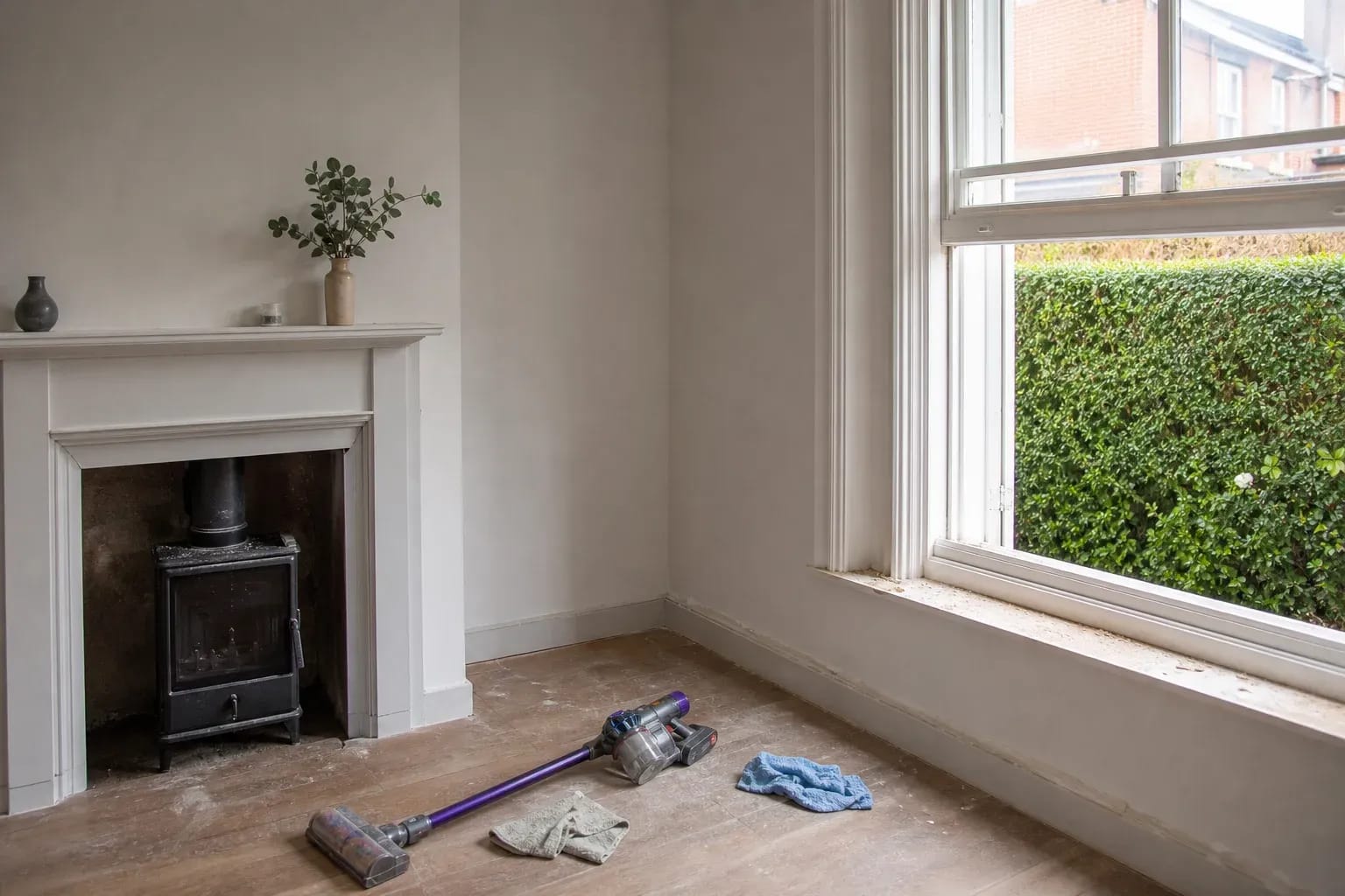 UK living room after light renovation with construction dust and vacuum, documentary photo